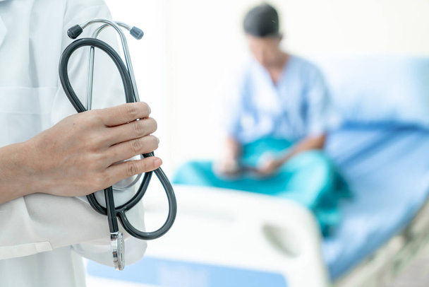 female doctor holding stethoscope with patient background - Φωτογραφία, εικόνα