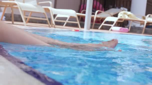 Female legs splashing in pool. - Metraje, vídeo