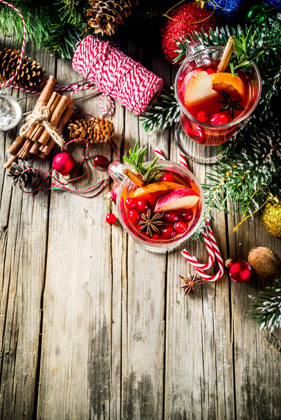 Traditional Christmas Mulled wine, grog or hot spicy sangria cocktail, on old rustic wooden table with christmas decorations and fir tree branches copy space top view - 写真・画像