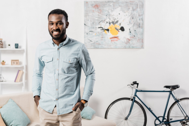 handsome african american man standing in living room - Photo, Image