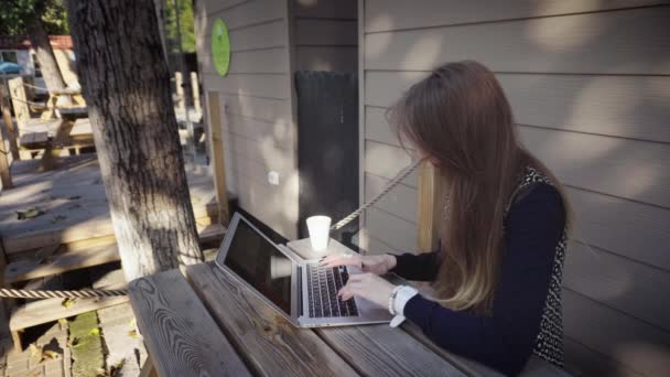 mulher digitando em um laptop ao ar livre
 - Filmagem, Vídeo