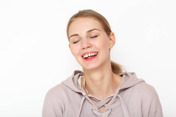 Portrait of laughing happy female model in white background. - 写真・画像