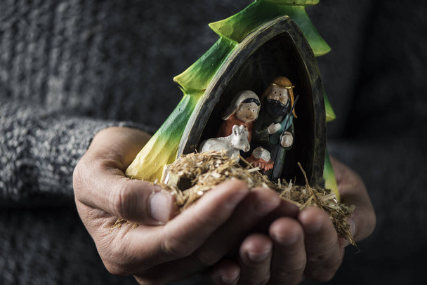la santa famiglia, il bambino Gesù, la vergine Maria e san Giuseppe, nelle mani di un giovane caucasico
 - Foto, immagini