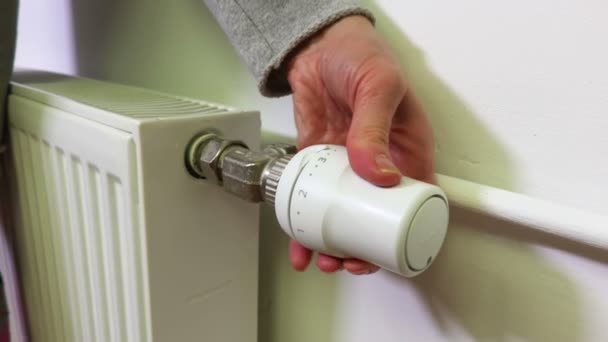 Mujer regula la temperatura del radiador de calefacción
 - Imágenes, Vídeo
