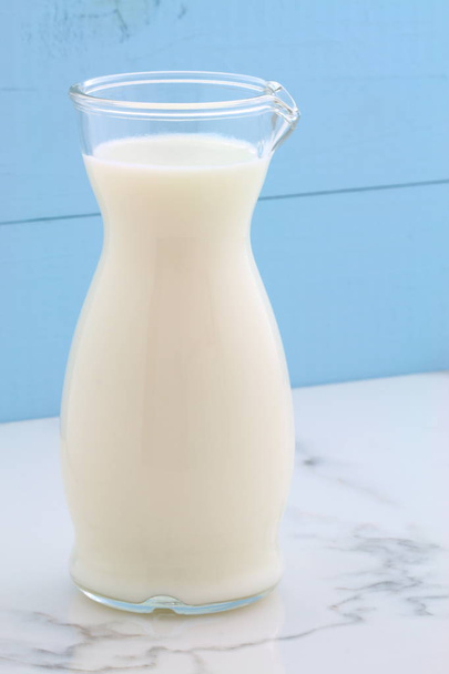 Heerlijke verse melk, een van de belangrijkste bronnen van voeding op vintage Italiaanse carrara marmer, boerderij styling keuken. - Foto, afbeelding