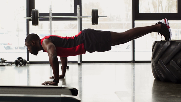 Afrikkalainen amerikkalainen urheilija tekee push ups kuntosalilla hidastettuna
 - Materiaali, video