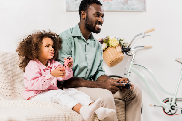 afro americano padre e figlia giocare video gioco in soggiorno
 - Foto, immagini