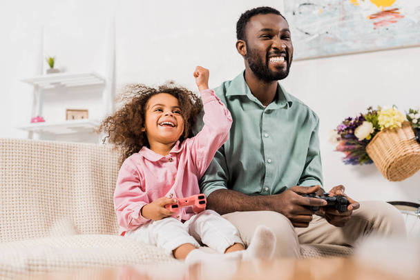 afro-américain papa rire avec fille et jouer jeu vidéo dans le salon
 - Photo, image