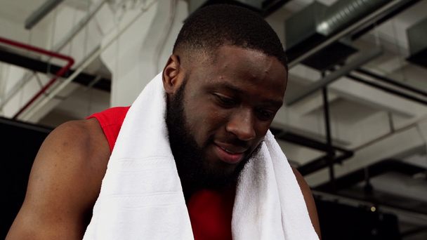 χαμογελώντας αφροαμερικάνος αθλητής με πετσέτα γυμναστηρίου σε αργή κίνηση - Πλάνα, βίντεο
