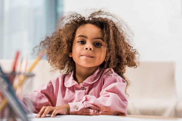 africké americké dítě kreslení s barevné tužky v obývacím pokoji - Fotografie, Obrázek