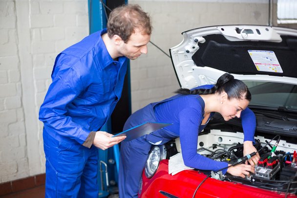 Car mechanics repairing the electrics - Фото, изображение