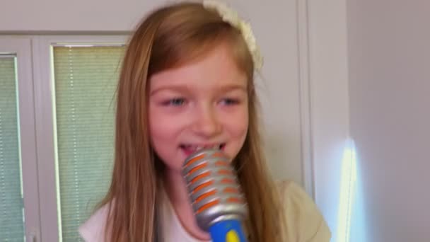 Улыбающаяся девушка с игрушечным микрофоном поет
 - Кадры, видео