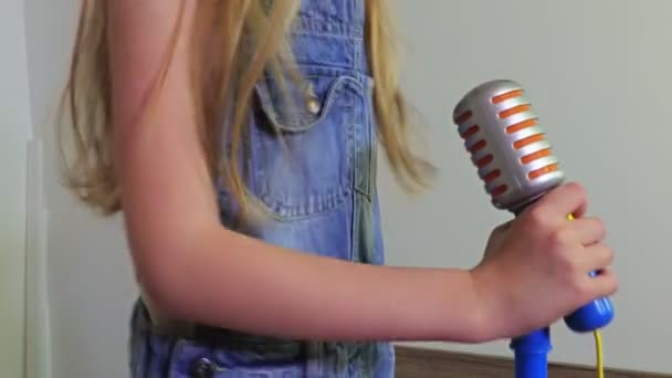 Menina com microfone de brinquedo perto
 - Filmagem, Vídeo