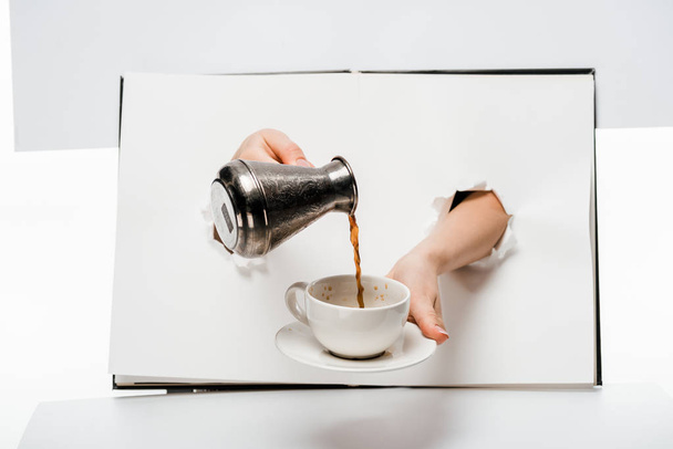 plan recadré de la femme verser du café dans la tasse à travers des trous sur blanc
 - Photo, image