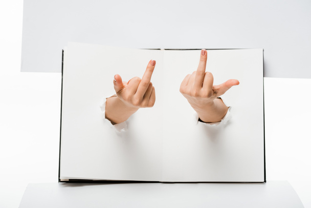 обрезанный снимок женщины, показывающей средние пальцы через отверстия на белом
 - Фото, изображение