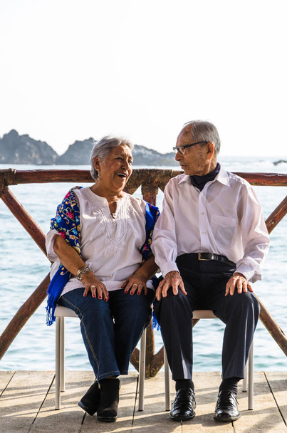 Bejaarde echtpaar kijken elkaar lachen. - Foto, afbeelding