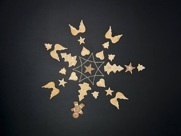 star shaped out of Christmas decoration items and cookies on black chalkboard background - Fotografie, Obrázek