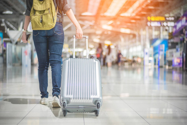 Красавица азиатка путешествует и держит чемодан в аэропорту. Концепция людей и образа жизни. Путешествуйте по миру. Вид сзади и нижний угол
. - Фото, изображение