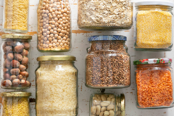 Various uncooked cereals, grains, beans and pasta for healthy cooking in glass jars - Foto, Bild
