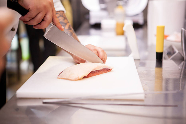 Chef slicing duck breast in kitchen restaurant - Foto, Imagen