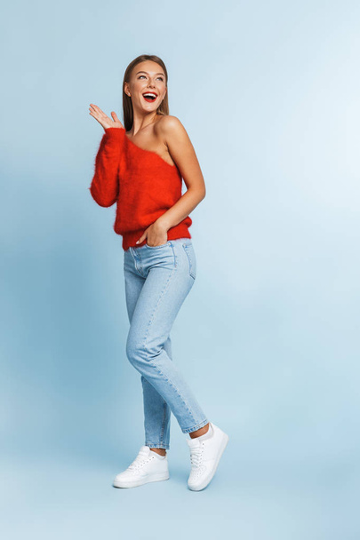 Image of a beautiful excited young woman posing isolated over blue wall background. - Foto, Imagem