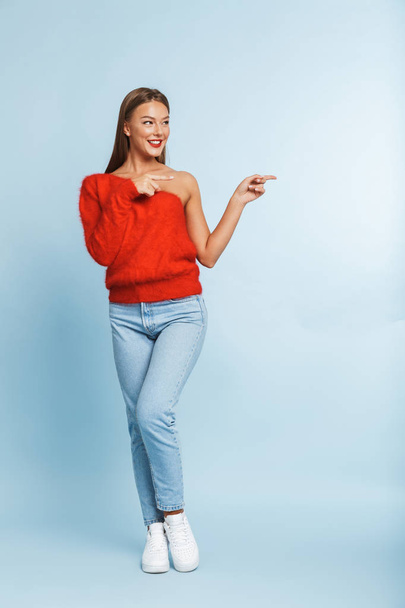 Image of a beautiful cute amazing young woman posing isolated over blue wall background showing copyspace. - Valokuva, kuva