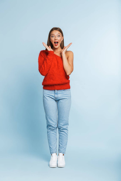 Image of a beautiful shocked young woman posing isolated over blue wall background. - Foto, imagen