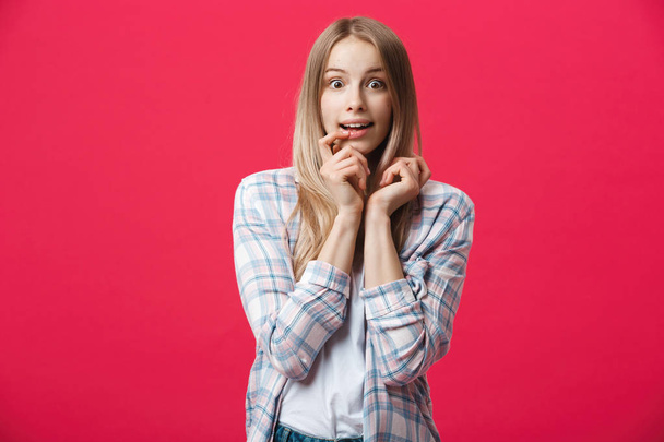Surprised teenage student girl show shocking expression with something. Isolated on Bright Pink Background. Copy space - 写真・画像