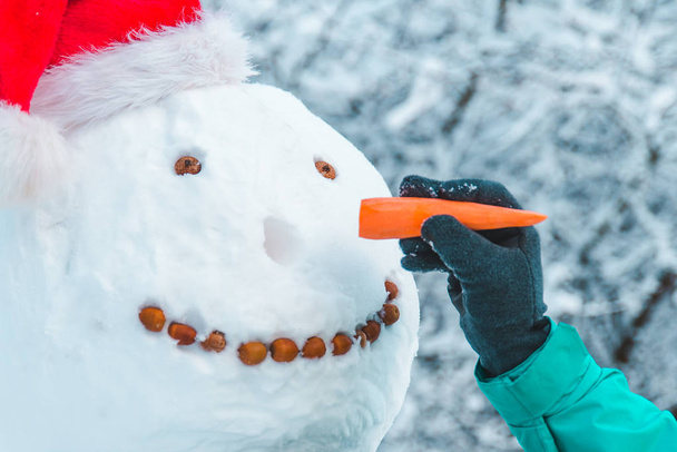 рука поклала морквяний ніс сніговику крупним планом концепція
 - Фото, зображення