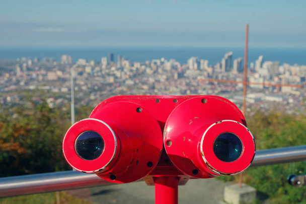 Vista da cidade turva do binóculo vermelho
 - Foto, Imagem