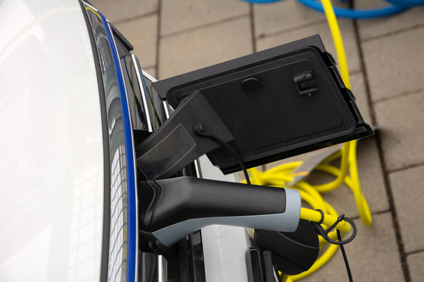 プラグ&ケーブル付き電気自動車の充電 - 写真・画像