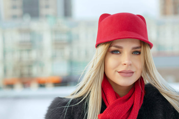 На відкритому повітрі портрет милої дівчини в стильній червоній шапці і в'язаний шарф. Простір для тексту
 - Фото, зображення