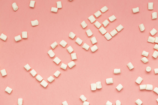 Marshmallows on pink background with copy space. Flat lay or top view. Background or texture of colorful mini marshmallows. Winter food background concept. - Фото, зображення