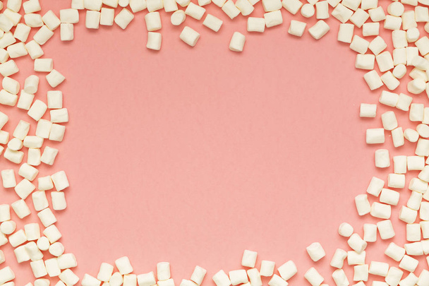 Marshmallows on pink background with copy space. Flat lay or top view. Background or texture of colorful mini marshmallows. Winter food background concept. - Fotó, kép