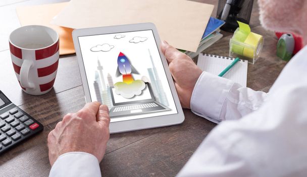 Startup-Konzept auf einem Tablet gezeigt, das von einem Mann gehalten wird - Foto, Bild