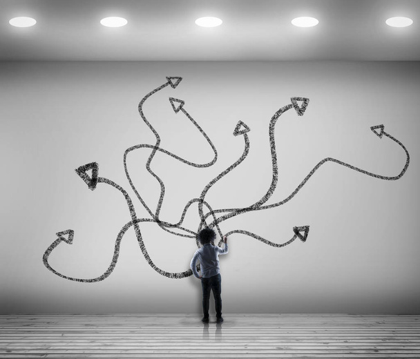 Businessman draws chaotic arrows on a white wall. - Photo, Image
