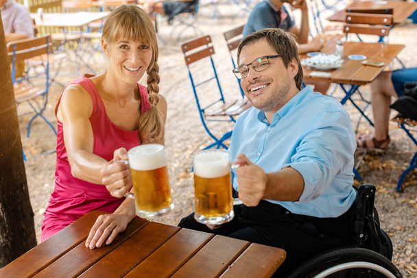 Postižený člověk v invalidní vozík a přítel pití piva - Fotografie, Obrázek