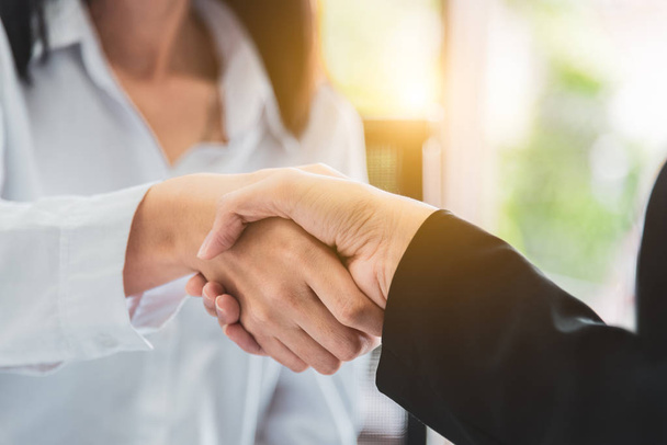 Close up of business people shaking hands after finish reach agreement for startup new project in office background. Negotiating and Happy working concept. People and teamwork theme - Photo, image