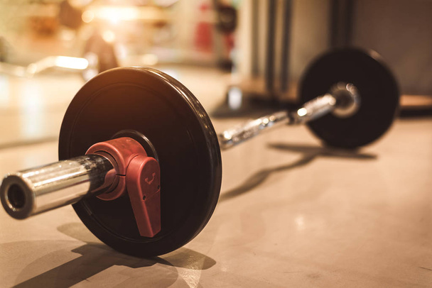 Siyah ağır çelik Barbell fitness spor spor salonu zemin üzerinde ayarlayın. Nesne ve egzersiz kavramı. Egzersiz eğitim ve vücut geliştiricisi. Spor donatımı ve aletleri için ağırlık güç'den aksesuarlar - Fotoğraf, Görsel