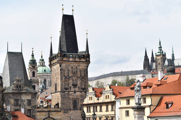 De twee torens in de buurt van Charles Bridge met de Sint-Vituskathedraal en Sint Nicolaas kerk in de achtergrond in Praag. - Foto, afbeelding