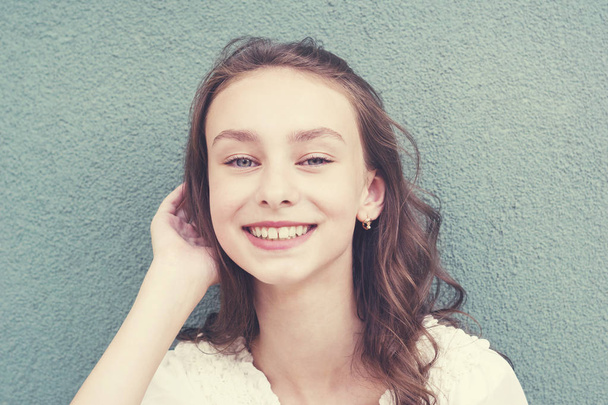 Χαρούμενα όμορφη κοπέλα με κυματιστά μαλλιά - Φωτογραφία, εικόνα