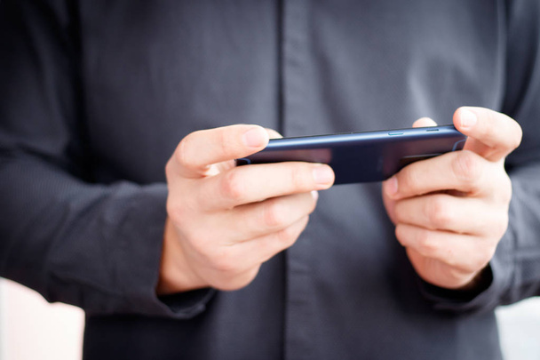 mužské ruky držící mobilní telefon a psaní sms - Fotografie, Obrázek