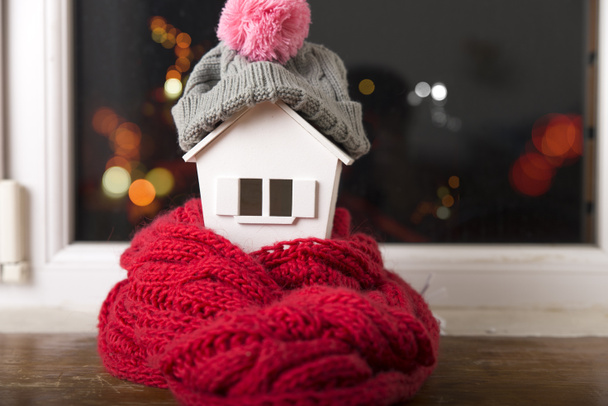 ház télen - fűtési rendszer fogalma, és a modell egy ház, egy kötött sapkát visel hideg havas Időjárás - Fotó, kép