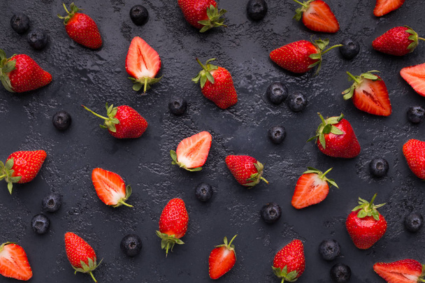 Blueberry and strawberry pattern on black background - Photo, Image
