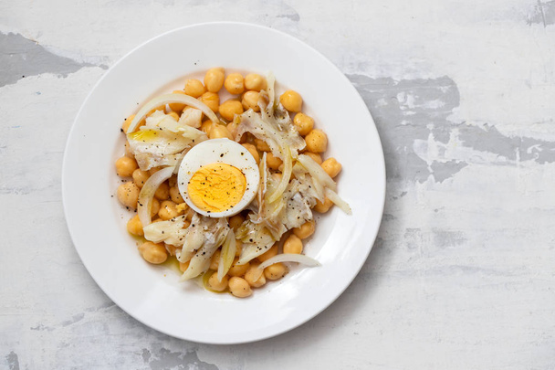chick-pea with cod fish and boiled egg on white plate - Photo, Image