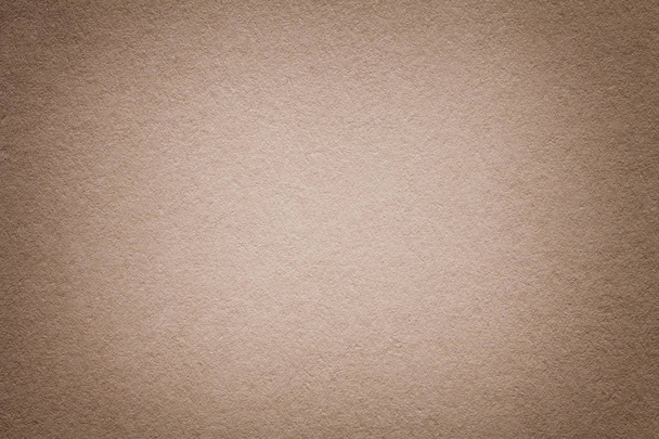 Texture of vintage dark beige paper background with vignette. Structure of dense light brown kraft cardboard with frame. Felt gradient backdrop closeup. - Photo, Image