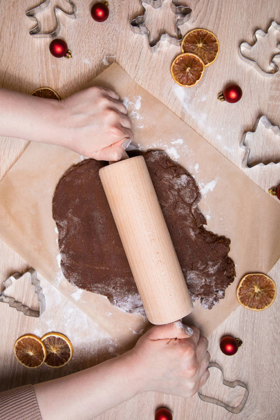 Toczenia ciasto, pieczenia pierniki mężczyzn, co świąteczne pierniki, cięcia cookie, domowe tradycyjne świąteczne desery. - Zdjęcie, obraz