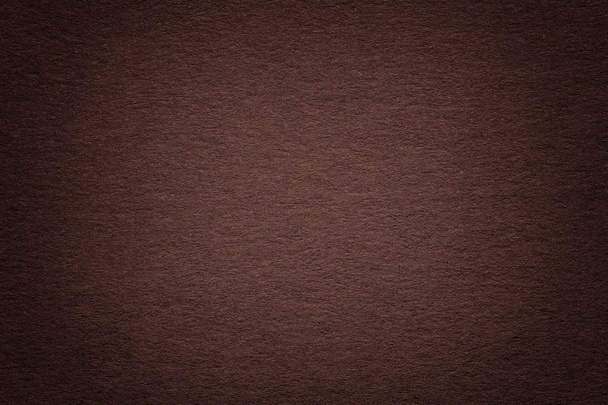 Texture of vintage dark umber paper background with vignette. Structure of dense brown kraft cardboard with frame. Felt gradient backdrop closeup. - Photo, Image