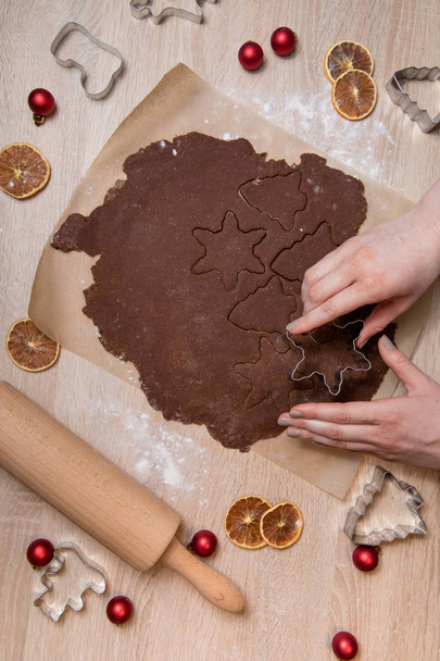 Cutting Christmas cookies, baking gingerbread men, making christmas cookie , homemade traditional  dessert. - Fotó, kép