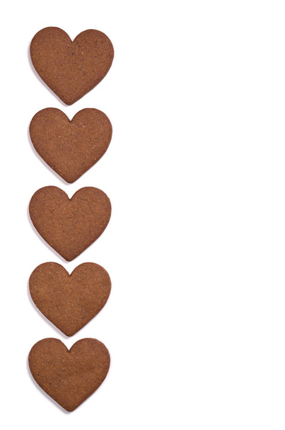 Biscoitos de gengibre em forma de coração sobre fundo branco, vista superior com espaço para texto
 - Foto, Imagem